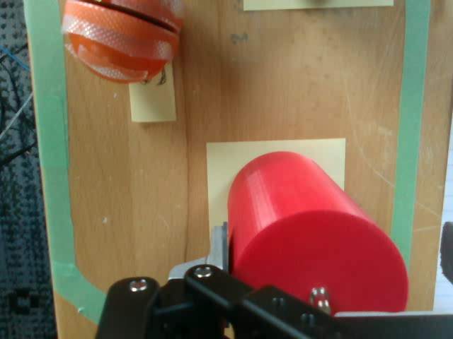 Wrist camera view of the red benchmark object beside the robot gripper during a SpaceMouse demonstration.